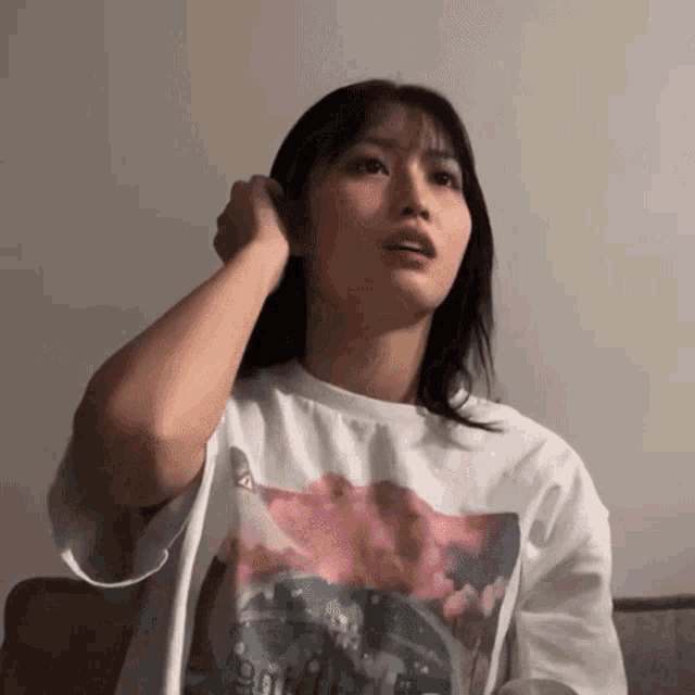 a woman in a white shirt is sitting on a couch .
