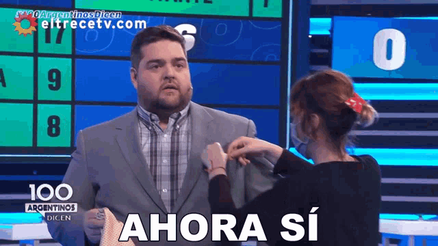 a man in a suit is being adjusted by a woman with the words ahora si on the bottom