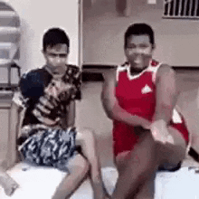 two men are sitting next to each other on a couch .