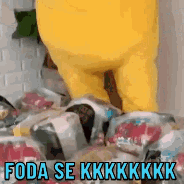 a yellow stuffed animal is standing on top of a pile of candy bags .