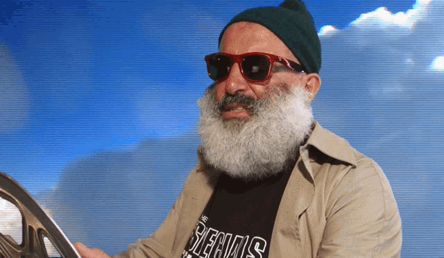 a man with a beard and sunglasses is wearing a shirt that says ' the beers ' on it