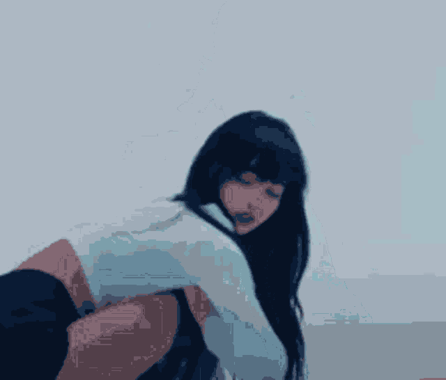 a woman in a white shirt and black shorts is kneeling on the floor