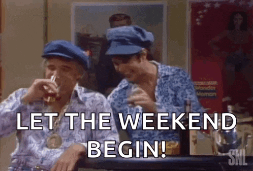 two men in blue hats are sitting at a table drinking beer and laughing .