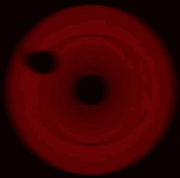 a close up of a red circle with three black spots on it .