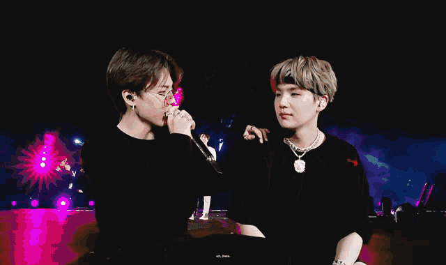 a man singing into a microphone with a band around his head that says ' bts '