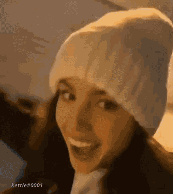 a close up of a woman wearing a white hat and scarf .
