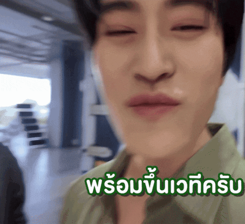 a blurry picture of a man 's face with the words " พร้อม " in green letters