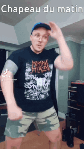 a man is wearing a hat and shorts and dancing in a room .