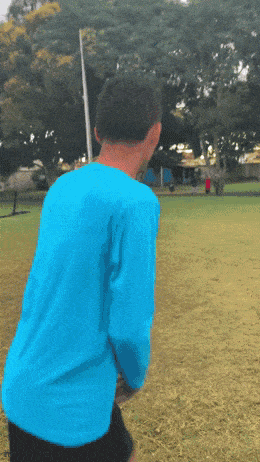 a man in a blue shirt stands in a field