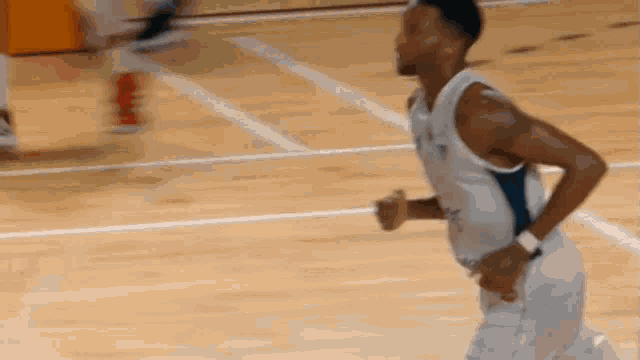 a basketball player is running on a wooden court .