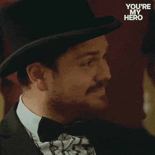 a man wearing a top hat and bow tie with the words you 're my hero below him