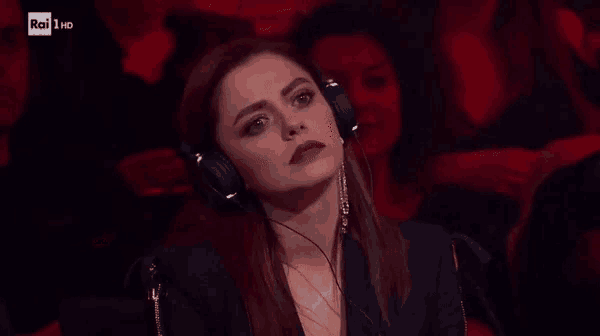 a woman wearing headphones is sitting in a dark room with rai hd written above her