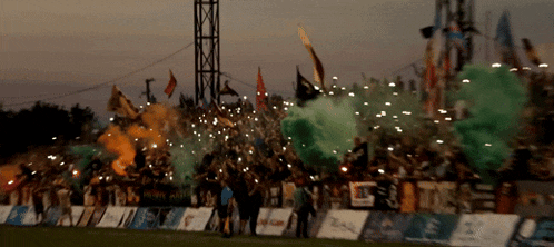 a blurred image of a soccer field with smoke coming out of the fans