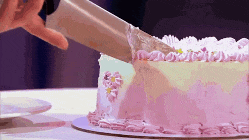 a person is cutting a cake with a knife on a table