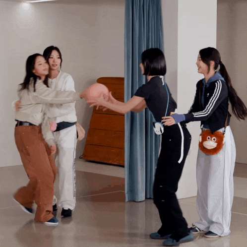 a group of girls are playing with a ball and one of them is wearing a monkey purse