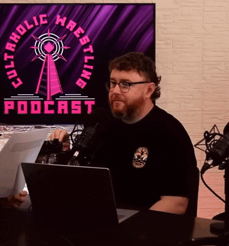 a man is sitting in front of a screen that says cult holic wrestling podcast
