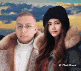 a man and a woman are standing next to each other in front of a cloudy sky