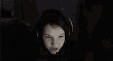 a woman is wearing headphones and making a funny face .