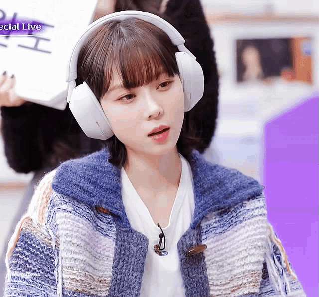 a woman wearing headphones is sitting in front of a sign that reads special live