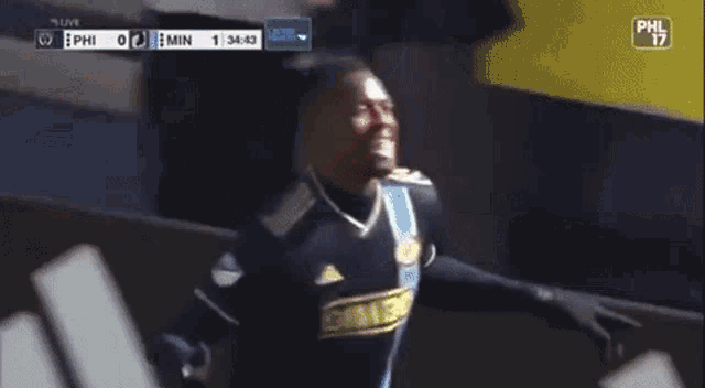 a soccer player celebrates a goal during a game with phil 17 on the screen