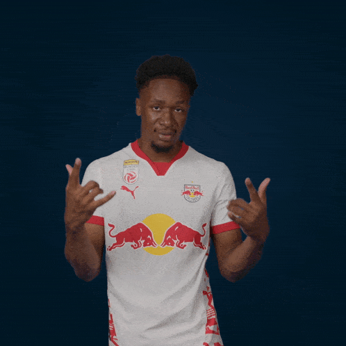 a man wearing a red bull jersey is making a devil horns sign