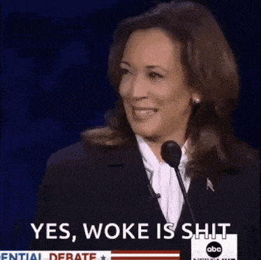 a woman is speaking into a microphone and smiling .