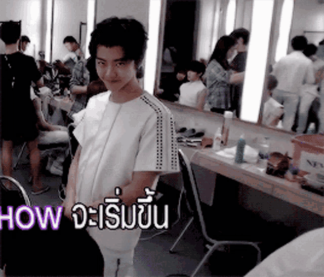 a man in a white shirt is standing in front of a mirror with the words now written on it