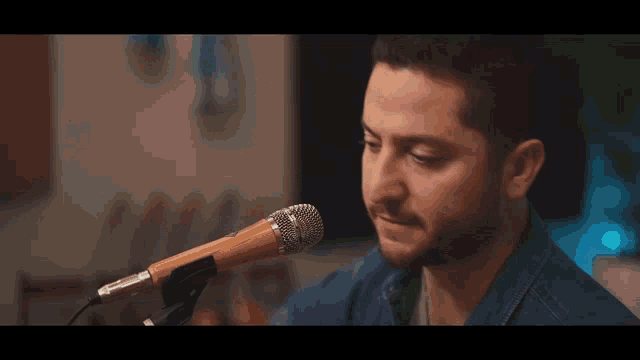a man singing into a microphone with a beard