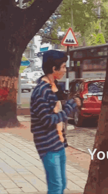 a man in a striped sweater holds a stuffed animal in his hands