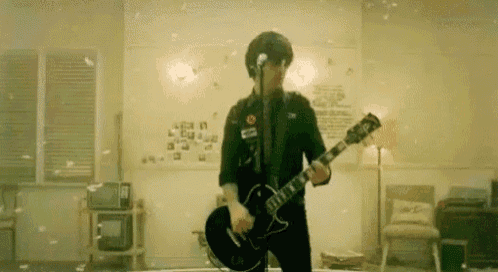 a man is playing a guitar and singing into a microphone in a living room .
