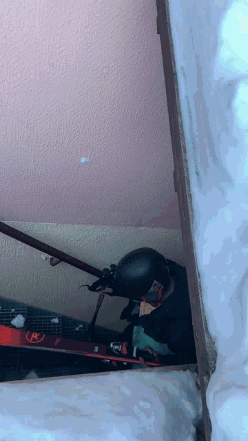 a person wearing a helmet and goggles is holding a pair of red skis that say ross on them
