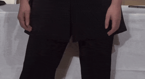 a person in black pants is standing in front of a white table