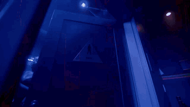 a woman in a white dress stands in a dark room