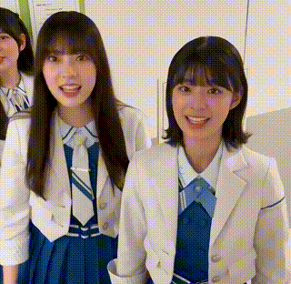 a group of girls are standing next to each other wearing suits and ties and smiling .