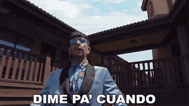 a man in a suit stands in front of a house with the words dime pa ' cuando above him