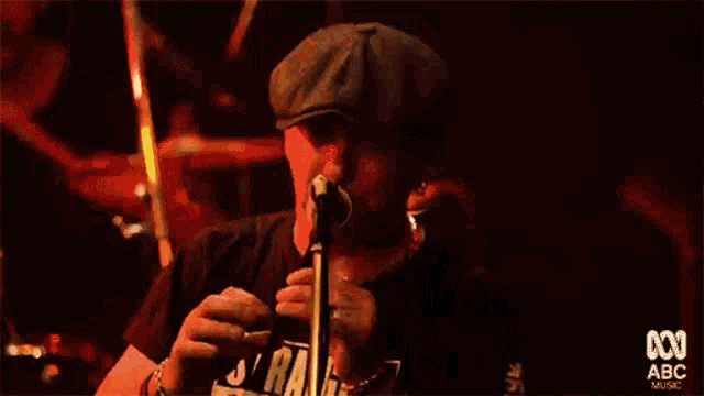 a man playing a flute in front of a microphone with abc music on the bottom