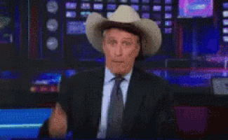a man in a suit and tie wearing a cowboy hat and tie