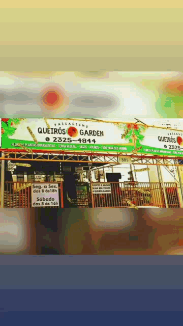 a sign for quetros garden is above a fence