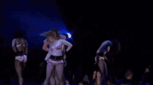 a woman in a pink bikini is dancing on a stage in front of a crowd that says security