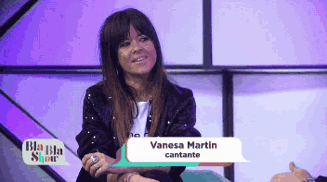 a woman is sitting in front of a screen that says vanesa martin cantante