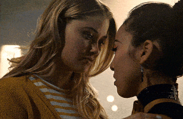 two women looking at each other with one wearing a choker