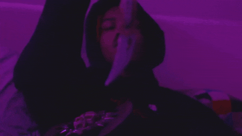 a close up of a person 's face in a purple room .
