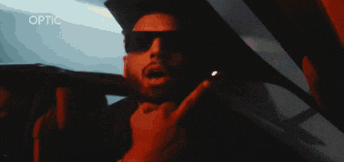 a man wearing sunglasses giving the middle finger in a car