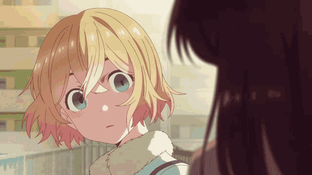 a girl with short blonde hair and blue eyes looks at another girl