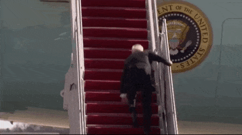 a man is walking up the stairs of an airplane with the seal of the president of the united states in the background .