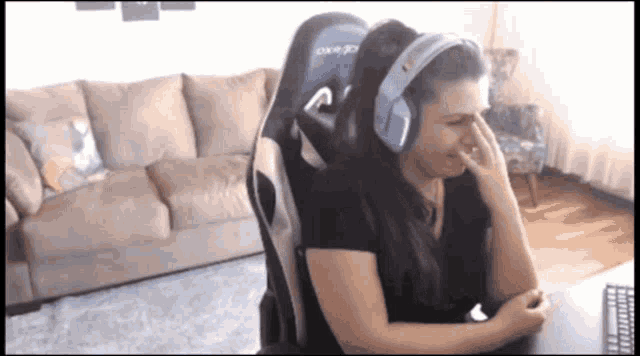 a woman wearing headphones sits in a dxracer gaming chair