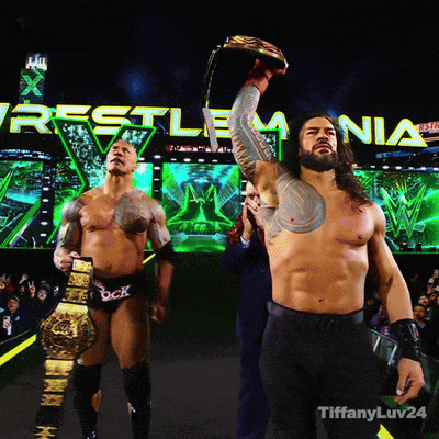a man holding a trophy in front of a wrestlemania sign