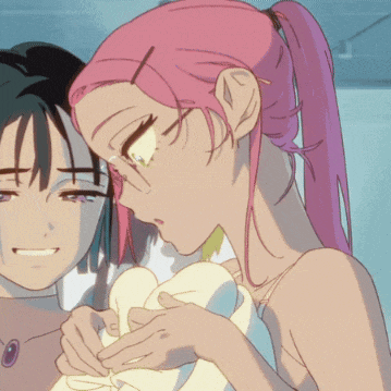 a girl with pink hair and glasses holds a pillow