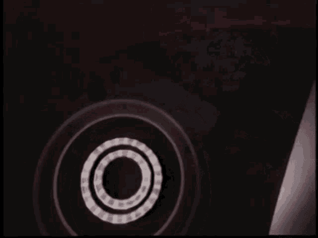 a group of people are dancing in a dark room in front of a circle .