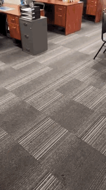 a carpeted floor in an office with desks and chairs